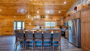 a kitchen with a table and chairs and a refrigerator at Sleeps 24 2 Homes Hot Tub Sauna Movie Theater Firepit Pool Tennis Courts in Gatlinburg