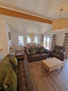 a living room with a couch and a table at Hot Tub Lake District Lodge - Windermere in Troutbeck Bridge
