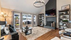 a living room with a couch and a fireplace at Lakefront Home w Dock Game Room Hot Tub Ponderosa Peninsula by AvantStay in Mayhew