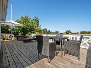 a deck with a table and chairs and an umbrella at Holiday Home Elfrede - 600m from the sea by Interhome in Kerteminde