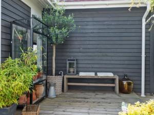 a wooden patio with a bench on the side of a house at Holiday Home Elfrede - 600m from the sea by Interhome in Kerteminde +22 photos