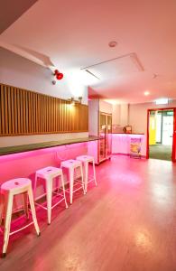 a pink bar with stools in a room at Rotorua Downtown Backpackers in Rotorua