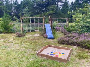 a playground with a sand pit and a slide at Holiday Home Orpah - 2-5km from the sea by Interhome in Kongsmark