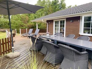 a deck with a table and chairs and an umbrella at Holiday Home Orpah - 2-5km from the sea by Interhome in Kongsmark