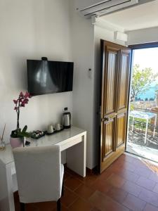 a room with a desk with a television on the wall at Villa Greta Hotel Rooms & Suites in Taormina +95 photos