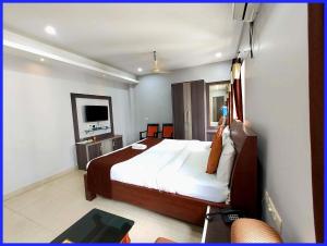a hotel room with a bed and a television at Rooftop Sea View Boutique Shivangi Hotel Near Jagannath Temple 1400m - Restaurant- Lift and Free Parking Facilities - Fully Air Conditioning Premium Rooms- Best Sea Beach Hotel In Puri in Puri
