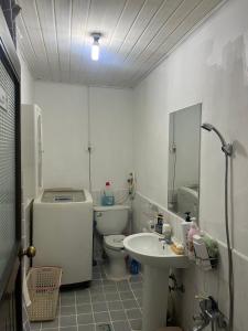 une salle de bain blanche avec toilettes et lavabo dans l'établissement Young Place, à Songt'an