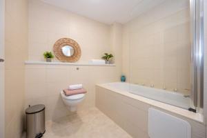 a bathroom with a toilet and a tub and a sink at Stunning Liverpool Dockside Apt by City SuperHost in Liverpool +27 photos