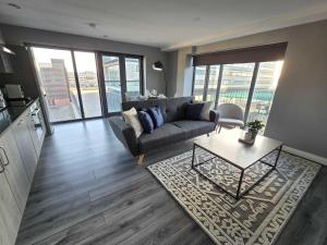 a living room with a couch and a table at Stunning Liverpool Dockside Apt by City SuperHost in Liverpool