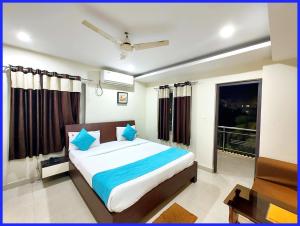 a bedroom with a bed with blue pillows and a window at Rooftop Sea View Boutique Shivangi Hotel Near Jagannath Temple 1400m - Restaurant- Lift and Free Parking Facilities - Fully Air Conditioning Premium Rooms- Best Sea Beach Hotel In Puri in Puri
