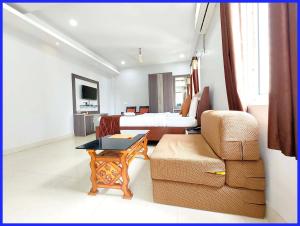 a bedroom with a bed and a couch and a chair at Rooftop Sea View Boutique Shivangi Hotel Near Jagannath Temple 1400m - Restaurant- Lift and Free Parking Facilities - Fully Air Conditioning Premium Rooms- Best Sea Beach Hotel In Puri in Puri +18 photos