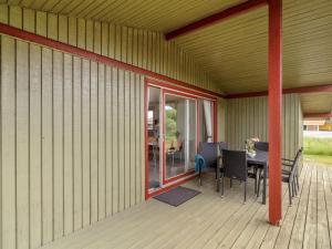 a porch with a table and chairs on a deck at Holiday Home Siv - from the sea by Interhome in Bjerregård