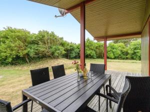 a wooden deck with a table and chairs on it at Holiday Home Siv - from the sea by Interhome in Bjerregård