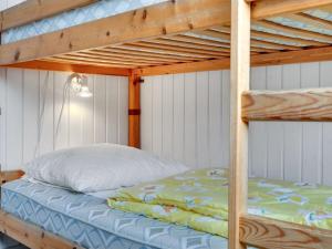 a bunk bed in a bedroom with a wooden bunk bed at Holiday Home Siv - from the sea by Interhome in Bjerregård +17 photos