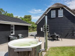 a bath tub in front of a black house at Holiday Home Benita - 400m to the fjord by Interhome in Skjern +61 photos