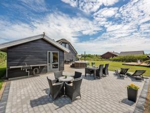 a patio with chairs and a table and a building at Holiday Home Benita - 400m to the fjord by Interhome in Skjern