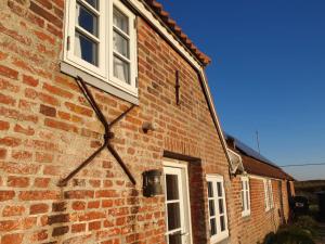 a brick building with a clock on the side of it at Holiday Home Answald - 250m from the sea by Interhome in Harboør +42 photos