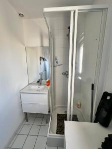 a white bathroom with a shower and a sink at Duplex familial lumineux , Plage à deux pas in Berck-sur-Mer