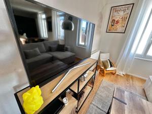 a living room with a large flat screen tv at Duplex familial lumineux , Plage à deux pas in Berck-sur-Mer +25 photos
