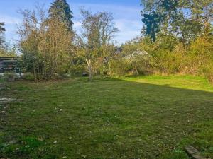 a field of grass with a tree in the middle at Holiday Home Alica - 200m from the sea by Interhome in Neksø