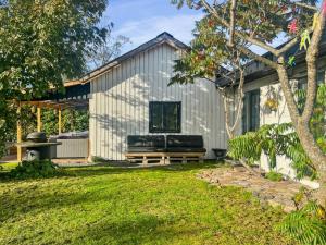 a white shed with a bench in a yard at Holiday Home Alica - 200m from the sea by Interhome in Neksø +21 photos