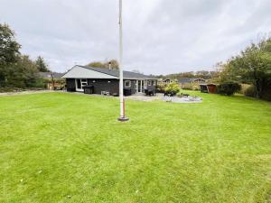 a house with a flag pole in a yard at Holiday Home Kjartan - 32m to the fjord by Interhome in Hemmet