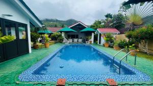 a swimming pool in front of a house at Villa Caballero in Au Cap