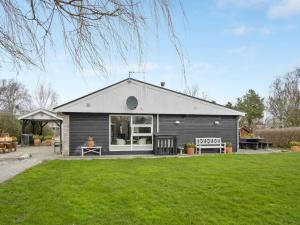 a small black house with a grass yard at Holiday Home Kjartan - 32m to the fjord by Interhome in Hemmet