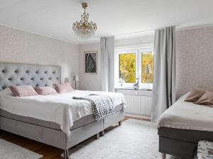 a bedroom with two beds and a chandelier at Holiday Home Skjutsmåla by Interhome in Olofström