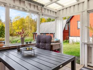 a patio with a wooden table and a chair at Holiday Home Skjutsmåla by Interhome in Olofström