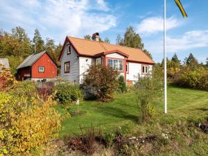 a house with an orange roof and a red barn at Holiday Home Skjutsmåla by Interhome in Olofström