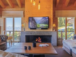 a living room with a fireplace and a tv at Chalet Chalet Gerritsen by Interhome in Nendaz