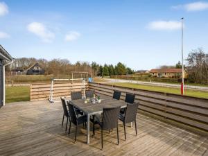 a dining table and chairs on a wooden deck at Holiday Home Amine - 300m to the fjord by Interhome in Skjern