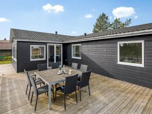 a patio with a table and chairs on a deck at Holiday Home Amine - 300m to the fjord by Interhome in Skjern