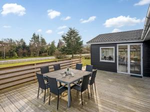 a patio with a table and chairs on a deck at Holiday Home Amine - 300m to the fjord by Interhome in Skjern