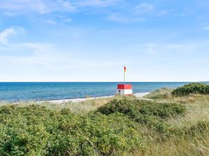 un faro rosso e bianco su una spiaggia con l'oceano di Holiday Home Rajna - 250m from the sea by Interhome a Gedser