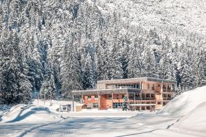 a building covered in snow in front of a mountain at Boutique Hotel LechZeit in Elmen