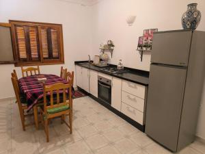 a kitchen with a refrigerator and a table and chairs at Younes résidence 3 in Asilah