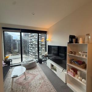 un salon avec un canapé et une table dans l'établissement Stylish Docklands Haven, à Melbourne