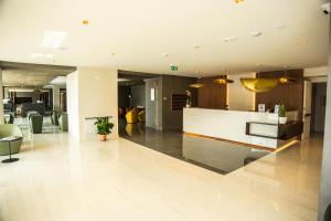 Un vestíbulo de oficina con un mostrador de recepción y sillas. en Hotel Perla del Gargano, en San Giovanni Rotondo