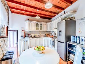 a kitchen with a table with a bowl of fruit on it at Holiday Home Prusina by Interhome in Smokvica