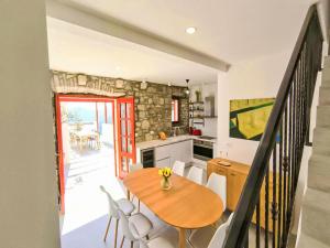 a kitchen and dining room with a wooden table and chairs at Holiday Home Prusina by Interhome in Smokvica +15 photos
