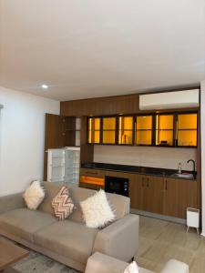 a living room with a couch and a kitchen at Cologne Residence in Mama