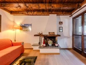 a living room with a fireplace and a couch at Apartment Mansarda al Doss by Interhome in Giustino