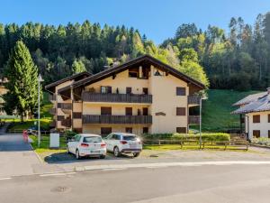 two cars parked in a parking lot in front of a building at Apartment Mansarda al Doss by Interhome in Giustino