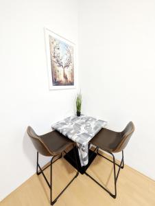 a table with two chairs and a table cloth on it at Comfortable Rooms in Wiener Stadthalle area G4 in Vienna