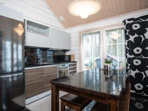 eine Küche mit Tisch und Kühlschrank in der Unterkunft Villa Huilinki in Ranua
