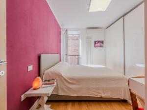 una camera con una parete rosa e un letto di Apartment Felicitahome by Interhome ad Arco