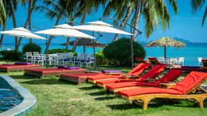 a group of lounge chairs and umbrellas next to a pool at Infinity Beach Club Resort & Hostel Koh Phangan in Baan Tai