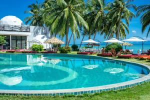 a swimming pool in front of a resort with palm trees at Infinity Beach Club Resort & Hostel Koh Phangan in Baan Tai